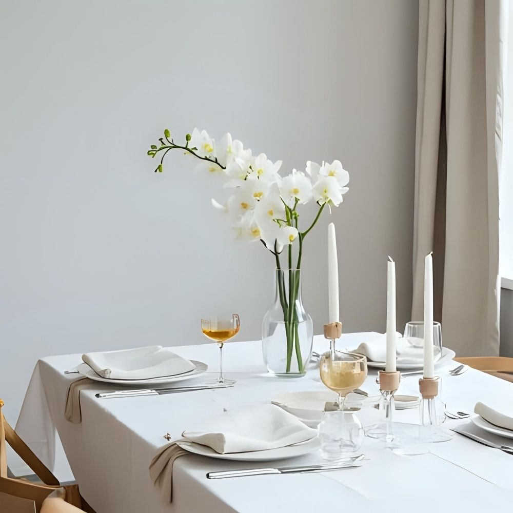 Minimalist table setting with white orchid centerpiece and clean ceramic plates