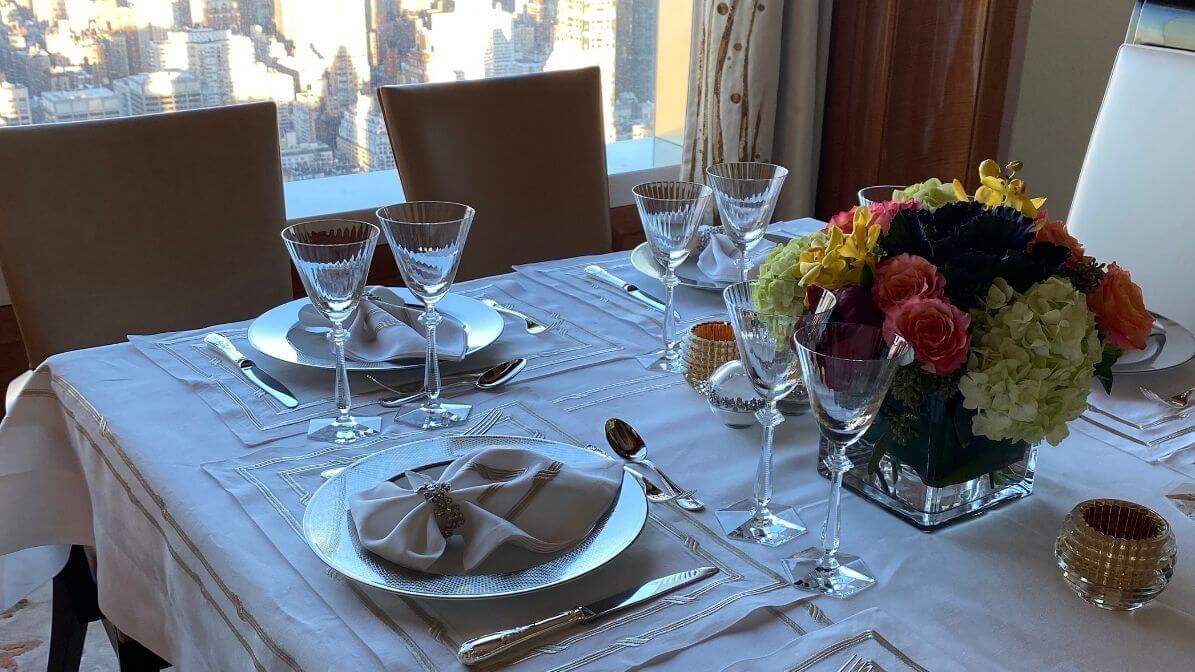 Luxury dinner table with cloth napkins and crystal glassware overlooking NYC skyline