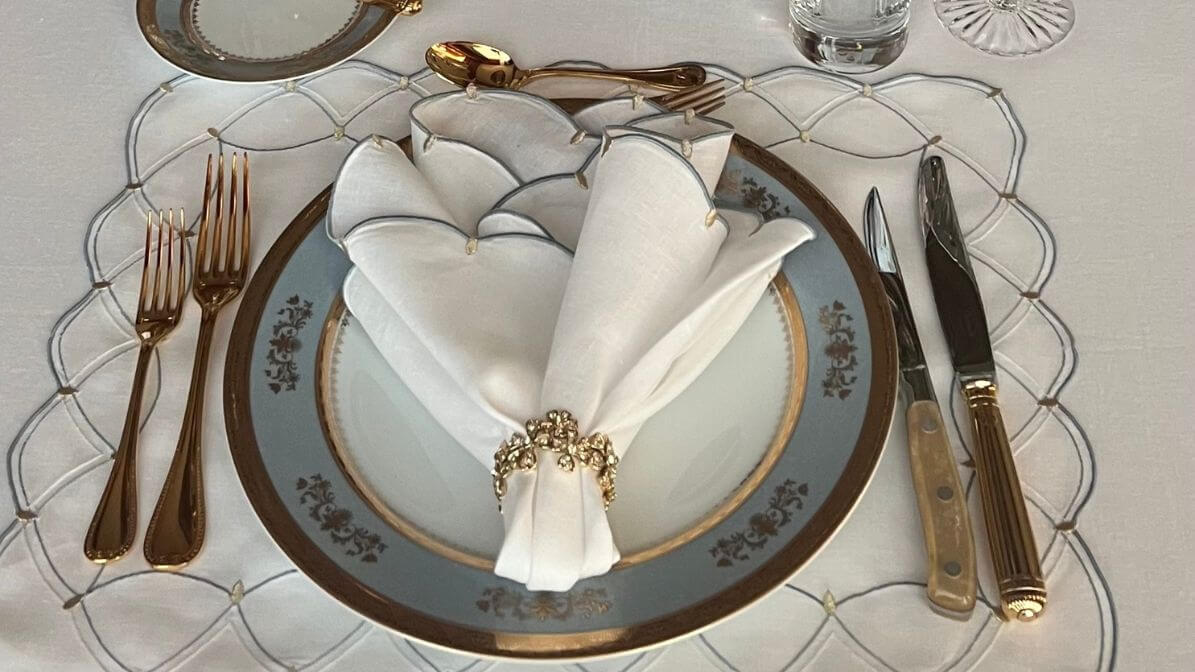 Crown napkin fold with white linen napkin and crystal ring on formal place setting