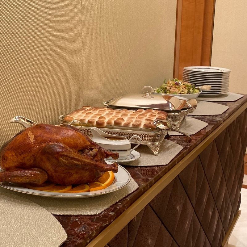 Buffet style dinner party setup with serving dishes and stacked plates