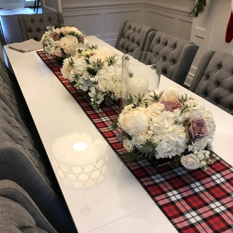 Day before dinner party checklist setup with candles, red peonies, and gold candlestick holders