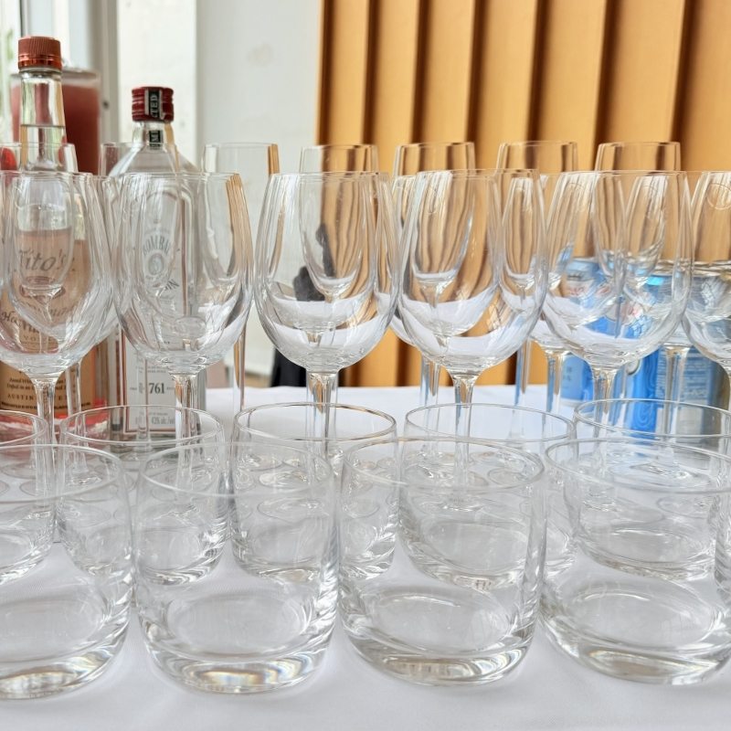 A few versatile glass shapes for a bar cart — wine stems and lowball glasses with spirits behind