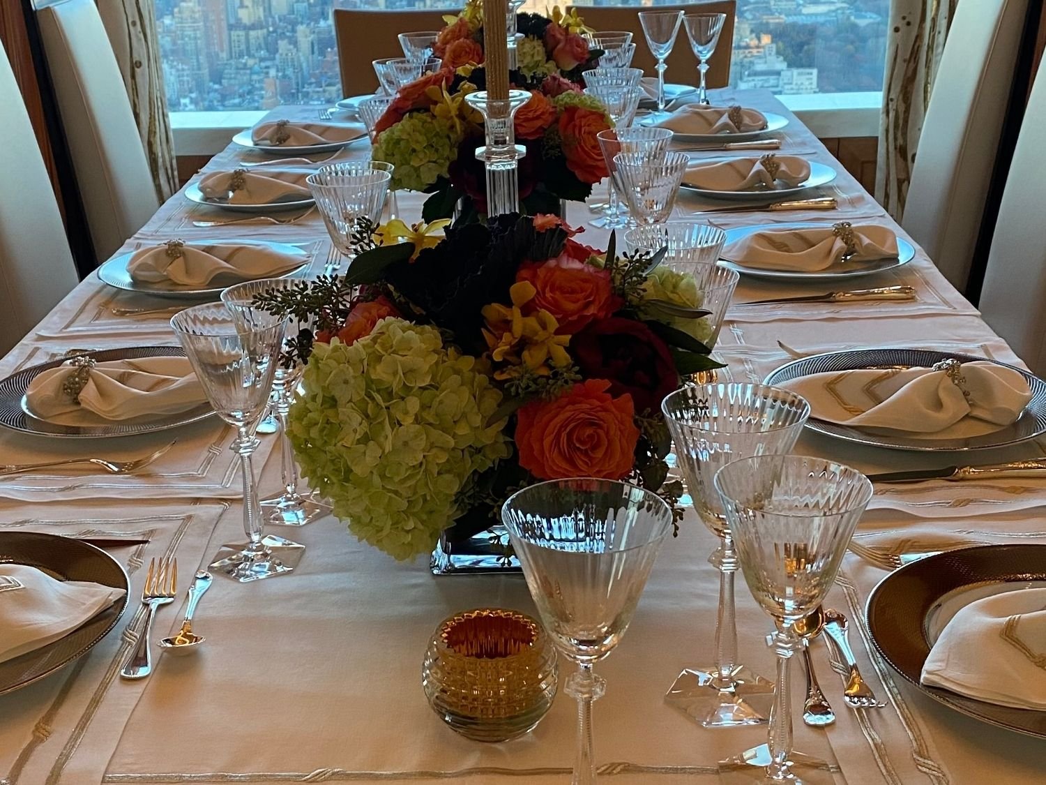 Formal floral centerpiece with orange roses and dark hydrangea at a Manhattan penthouse dinner