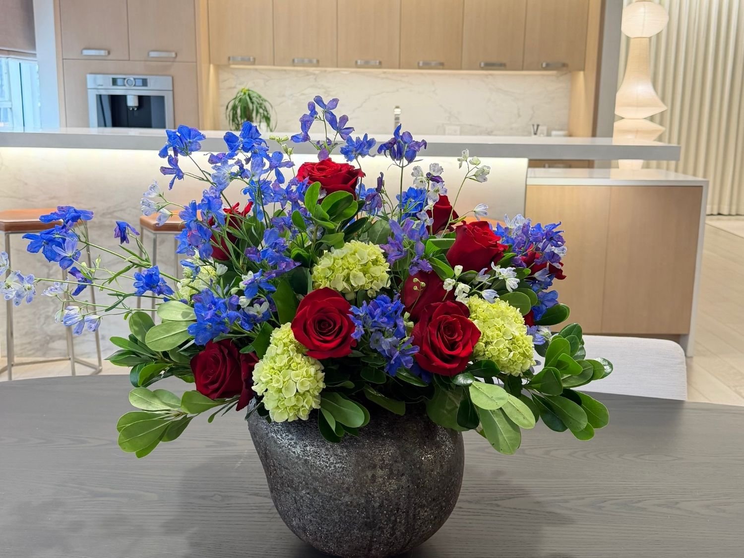 Same stone vase with yellow chrysanthemums and orchids for a spring kitchen table centerpiece